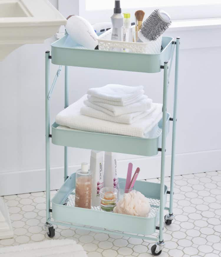 an aqua utility cart full of bathroom supplies