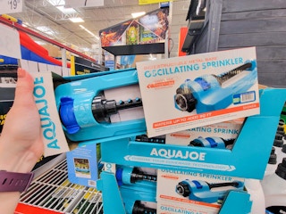 hand holding a teal sprinkler