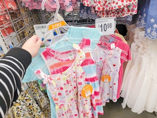 hand holding a set of 3 youth dresses