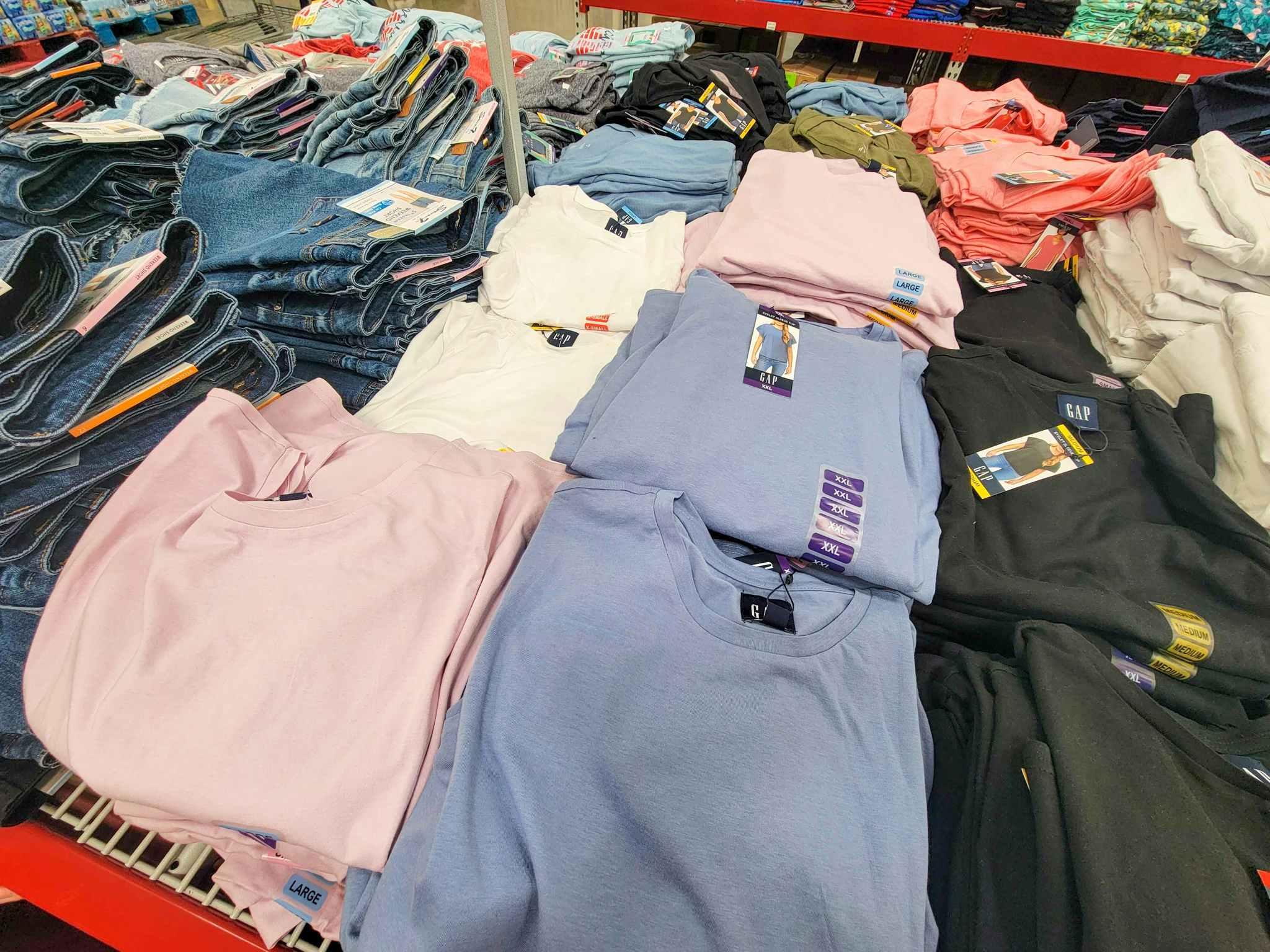 table with white, pink, and blue shirts