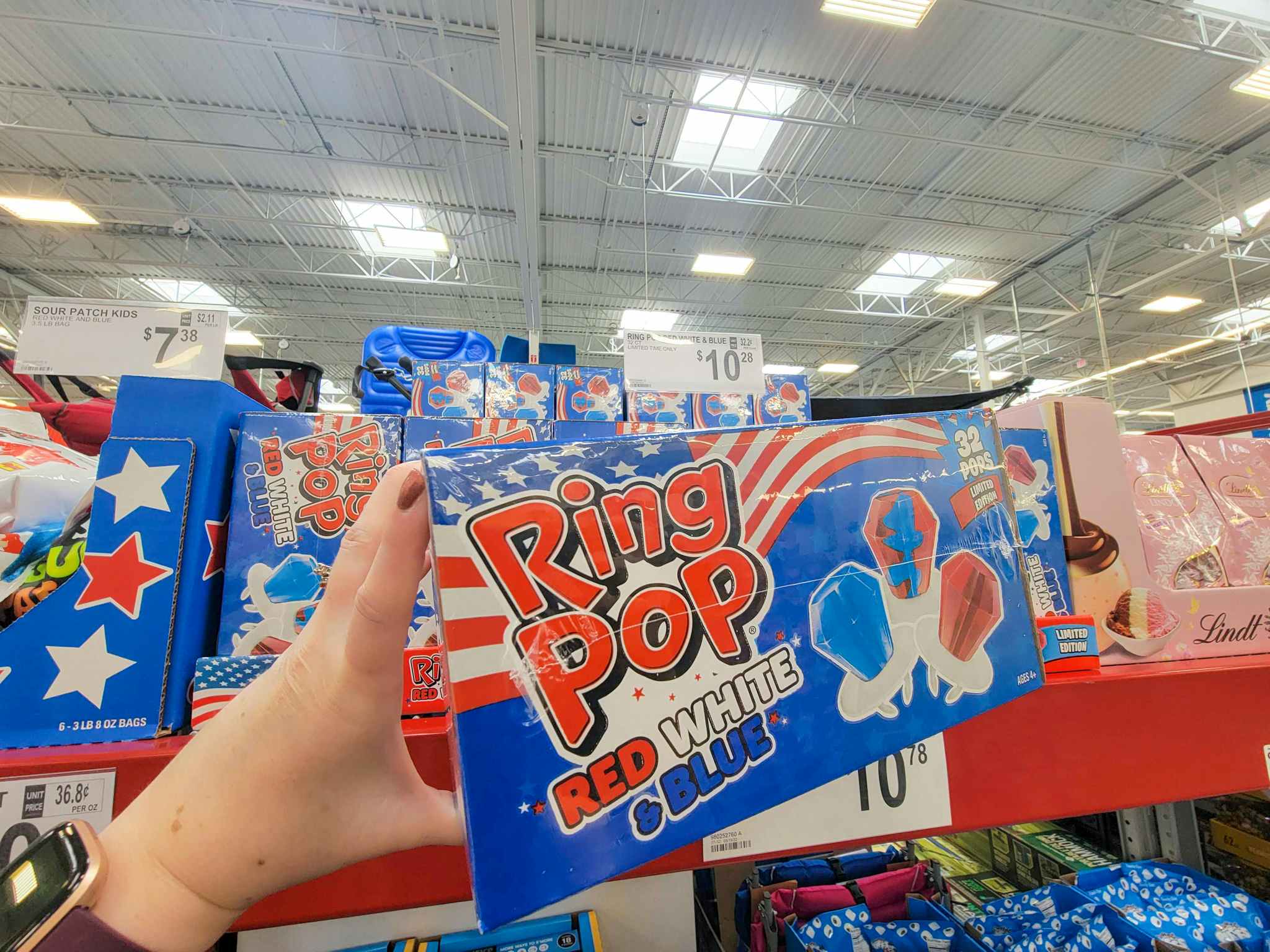 hand holding a box of red, white, and blue ring pops
