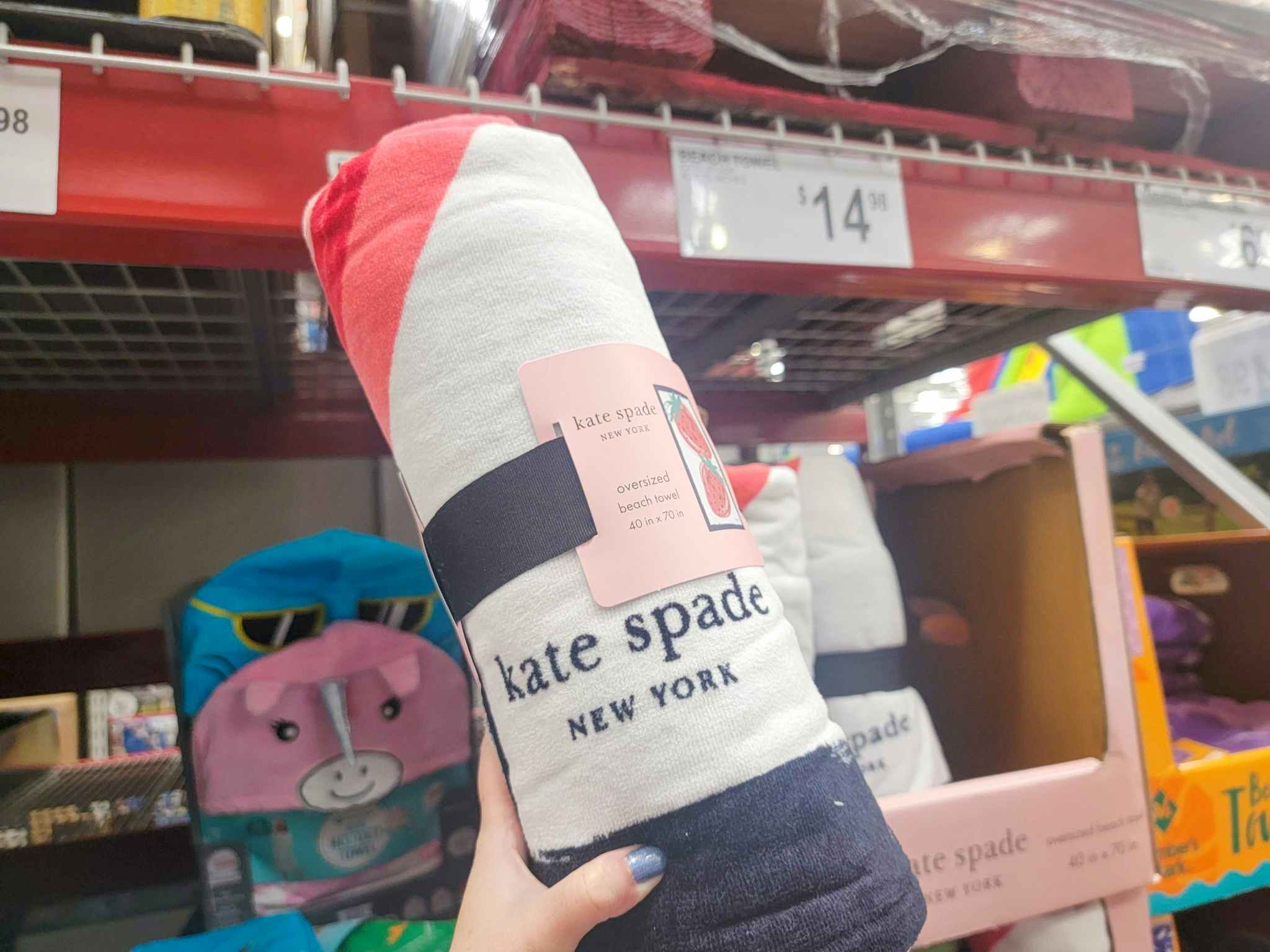 hand holding up a Kate Spade oversized beach towel