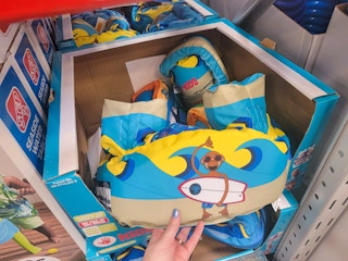 hand holding a kids body glove life jacket floatie