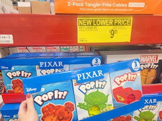 hand holding a 3-pack of pixar themed pop its