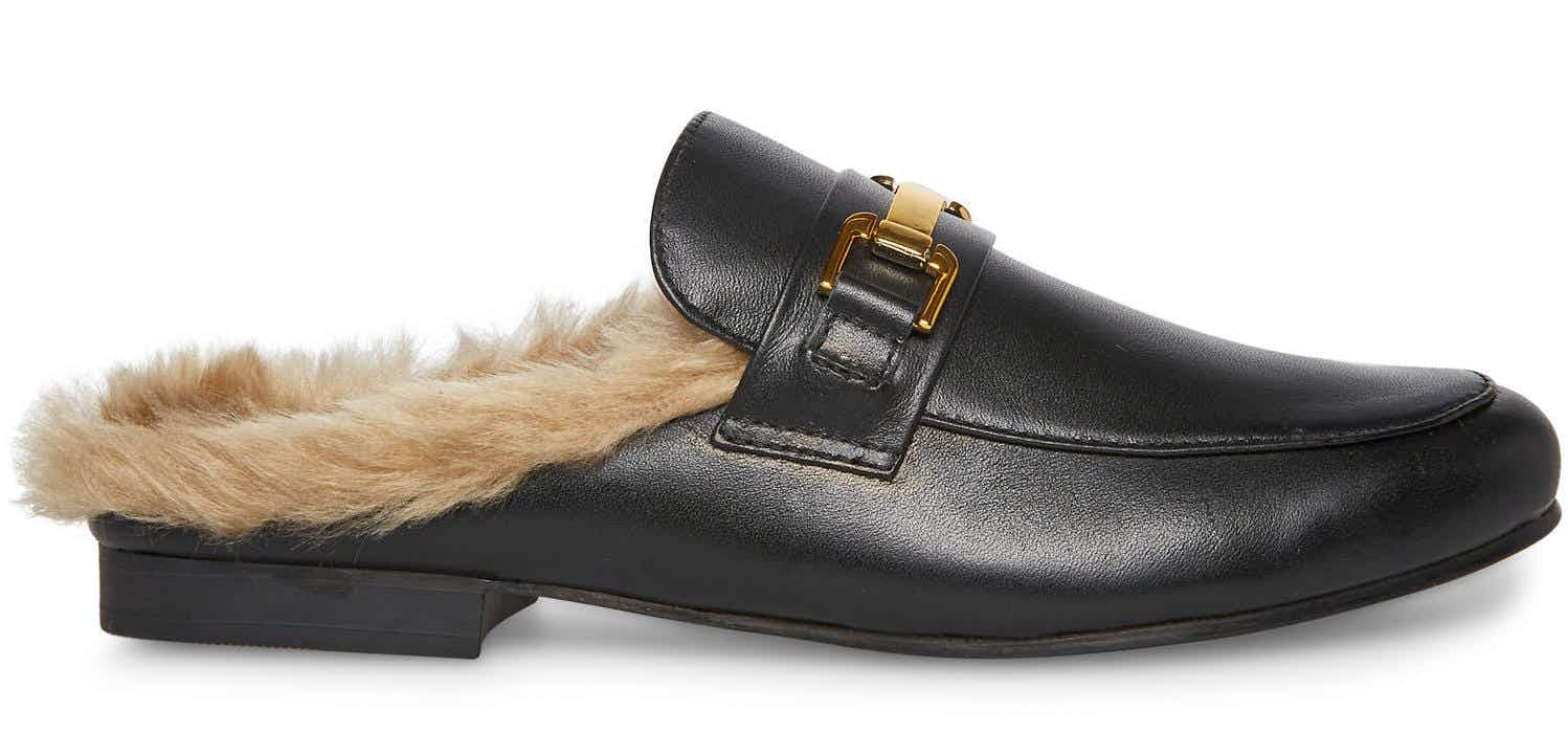 a black steve madden mule with faux fur in the foot bed and a gold buckle on top