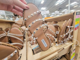 hand holding a tan studded sandal