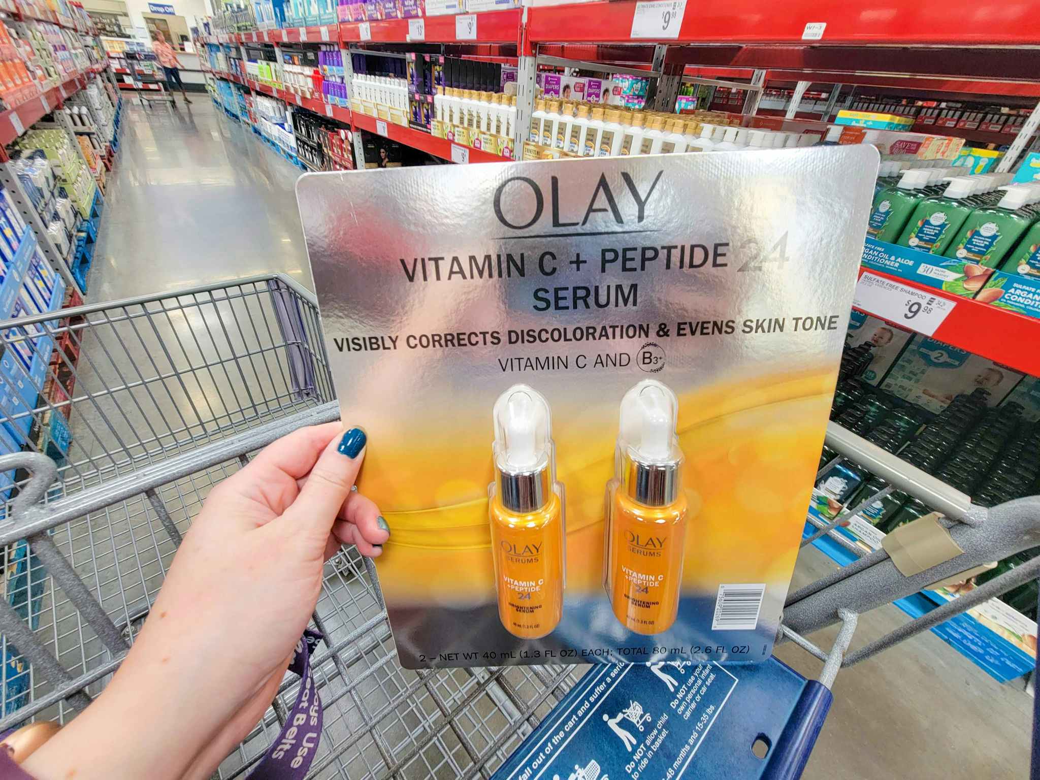 hand holding a 2-pack of olay vitamin c serums in a cart