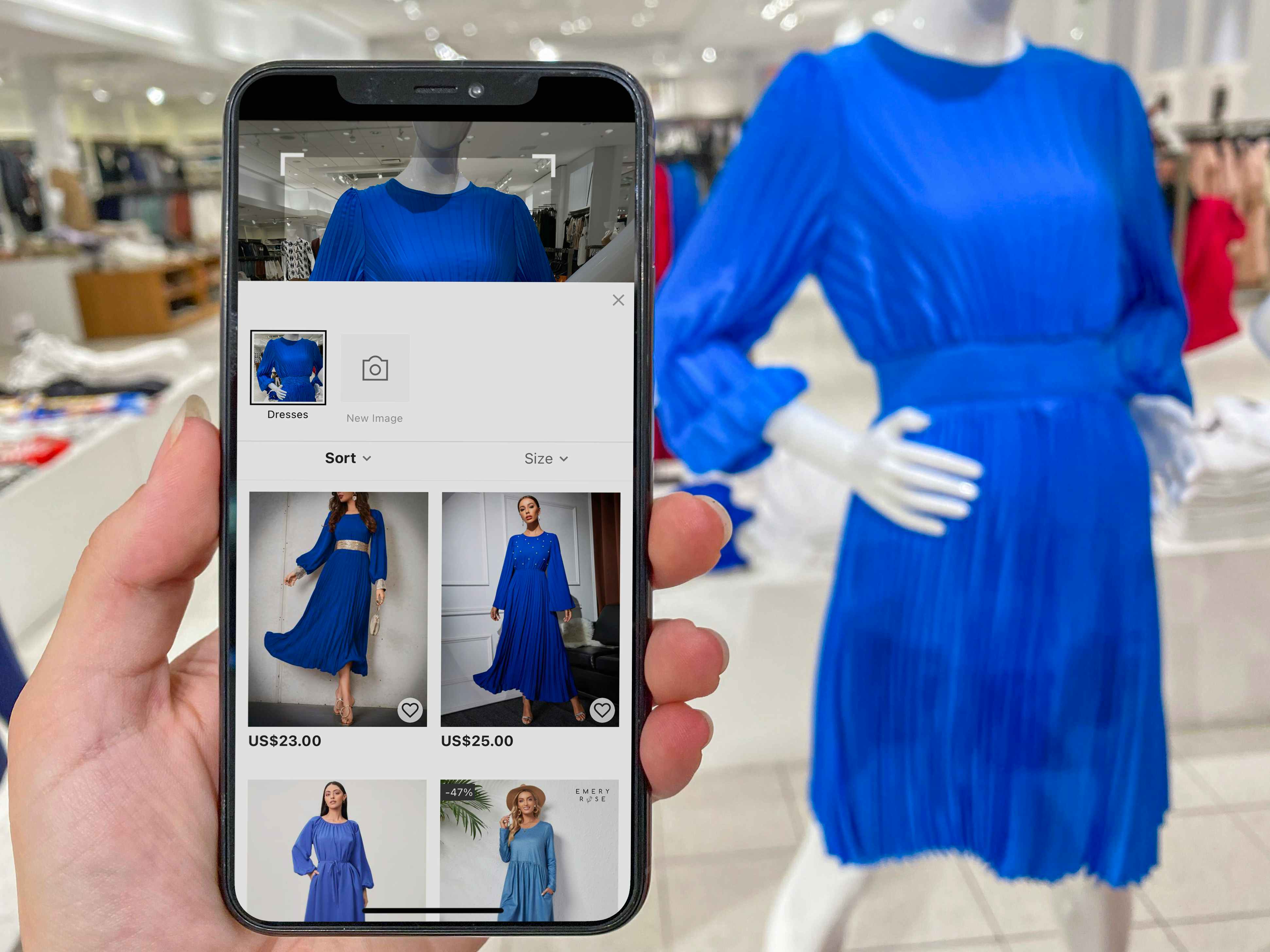 A person holding a cell phone with a screen displaying blue dresses on the SHEIN app, next to a similar blue dress on a mannequin inside a store.