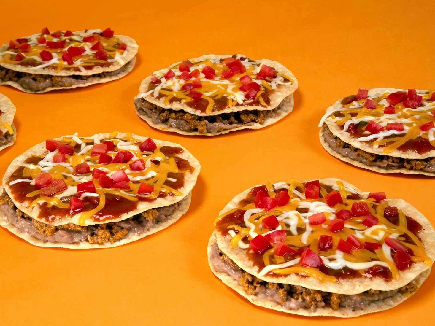Taco Bell Mexican pizzas on an orange background