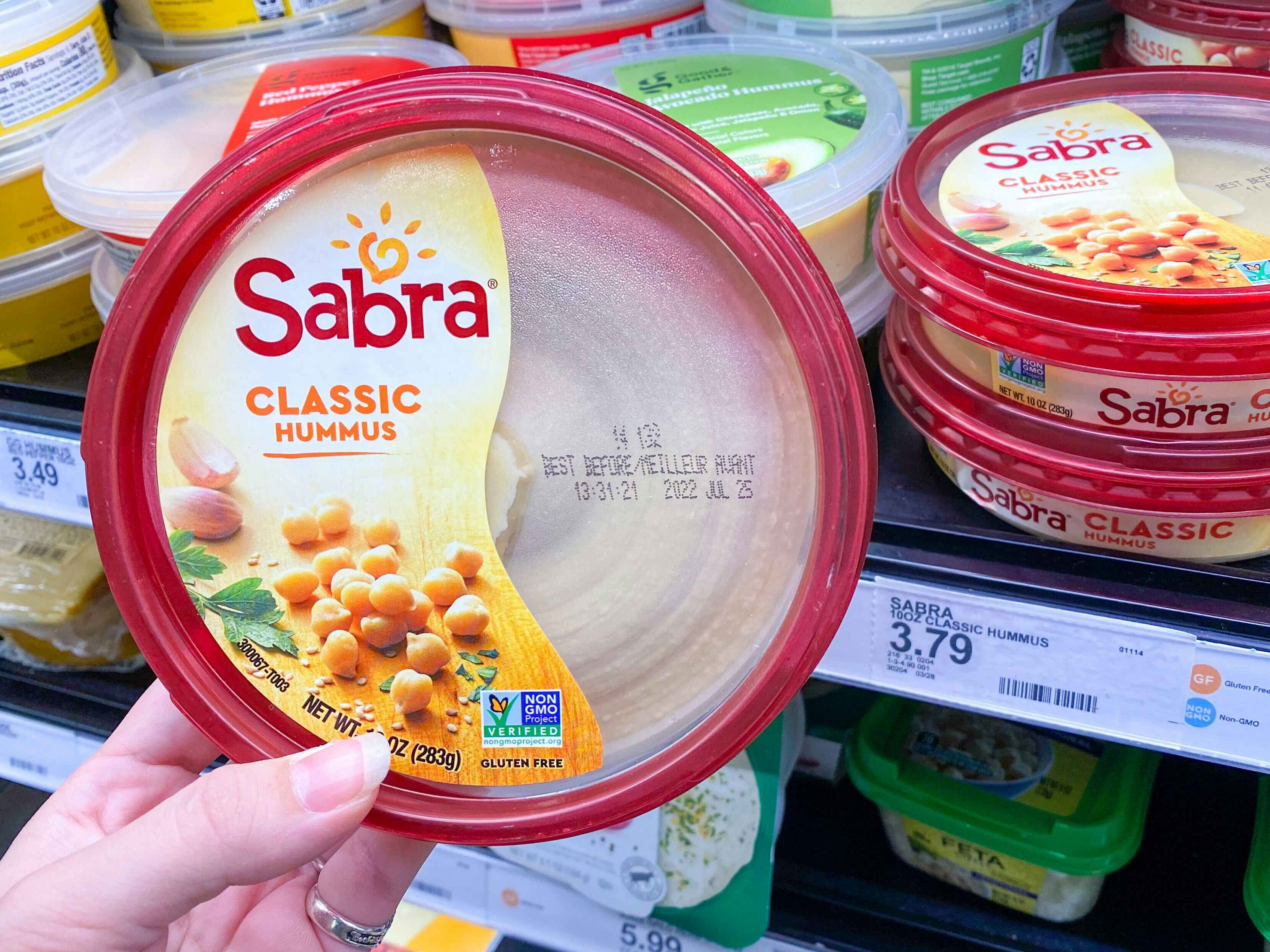 Sabra Classic Hummus held in front of shelf at Target. Price sticker on the shelf reads $3.79.