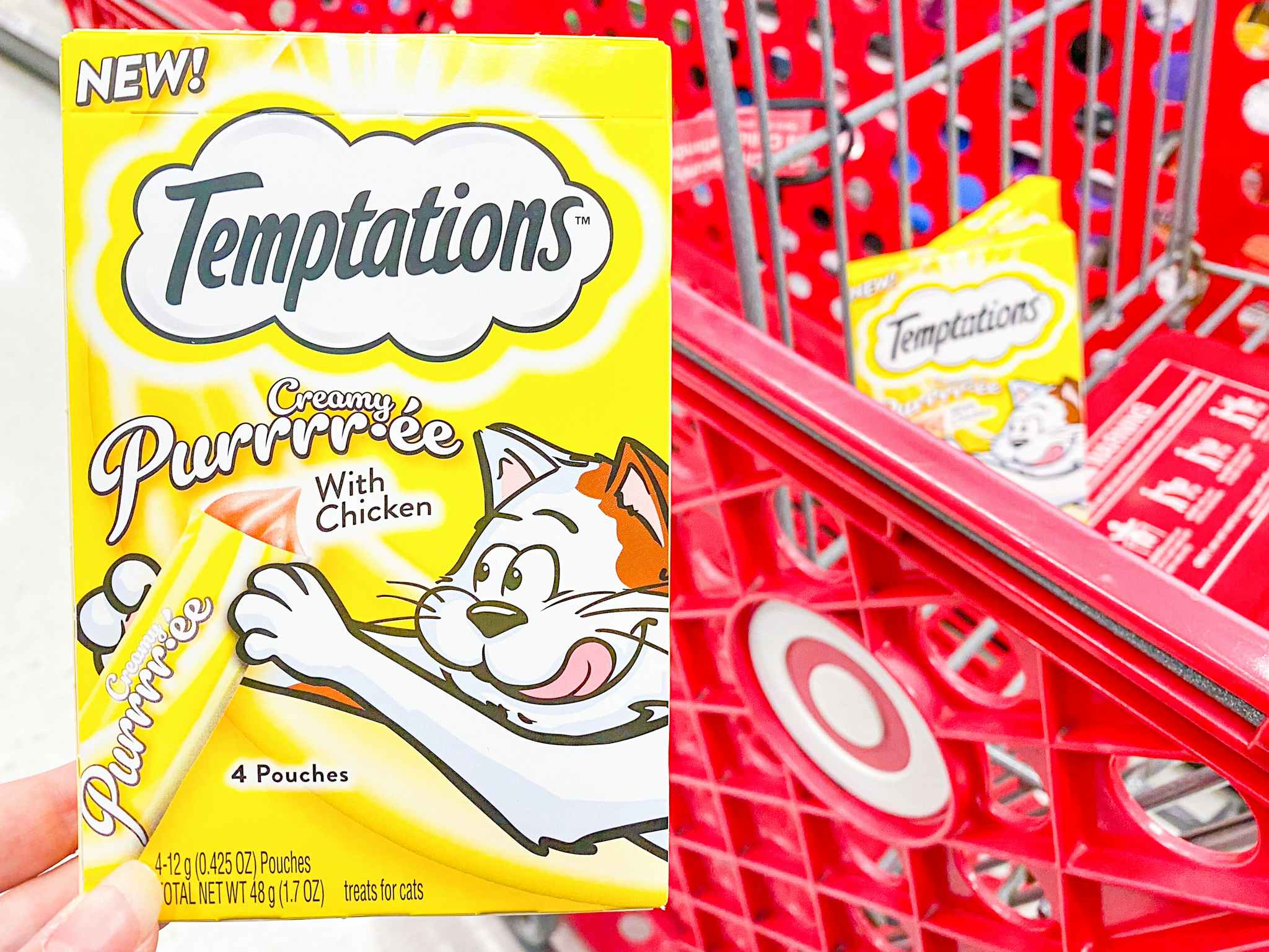 One package of Temptations Purre Cat Treats held in front of Target shopping cart