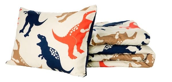 A Target Pillowfort set with a dinosaur-patterned pillow and blanket.