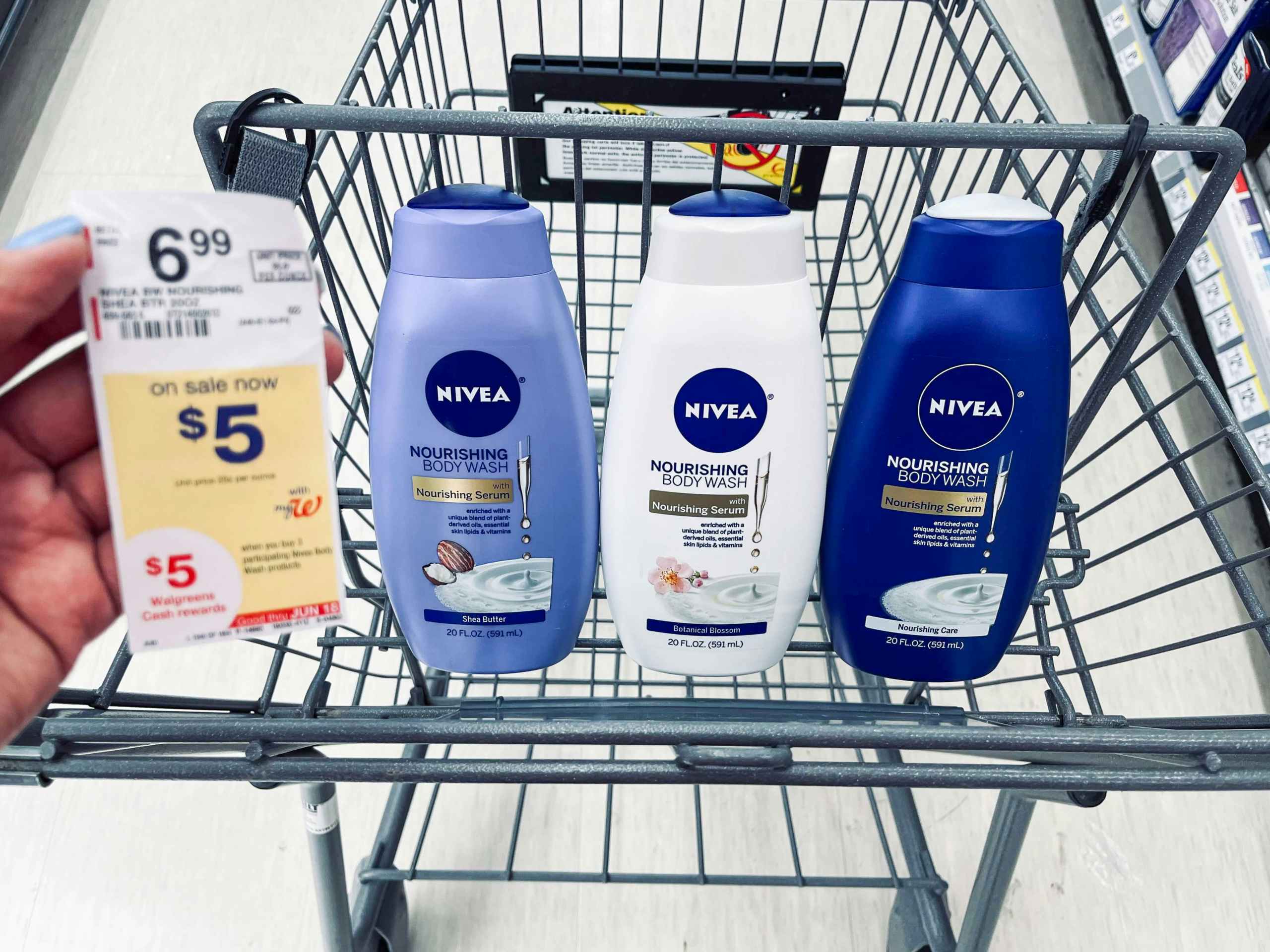 shopping cart with three bottles of Nivea body washes and hand holding sales tag in the air next to the bottles