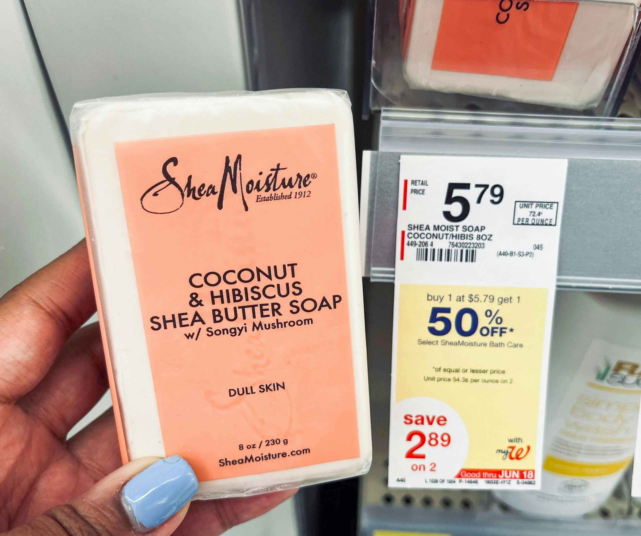 hand holding SheaMoisture Coconut & Hibiscus shea butter soap bar next to sales tag