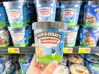 Ben & Jerry's Strawberry Cheesecake Ice Cream held in front of shelf full of Ben & Jerry's products at Walmart