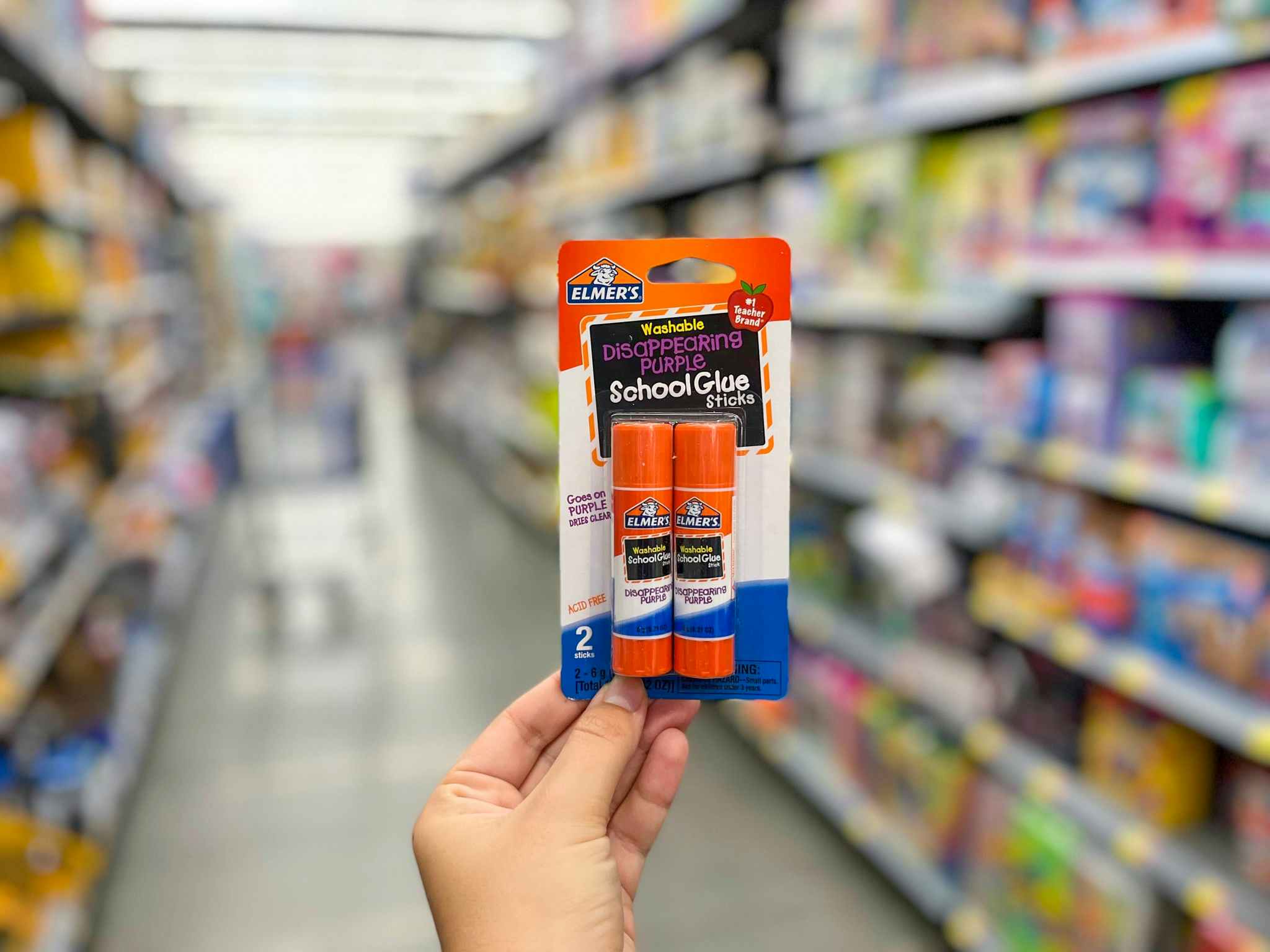 hand holding elmers school glue sticks at walmart