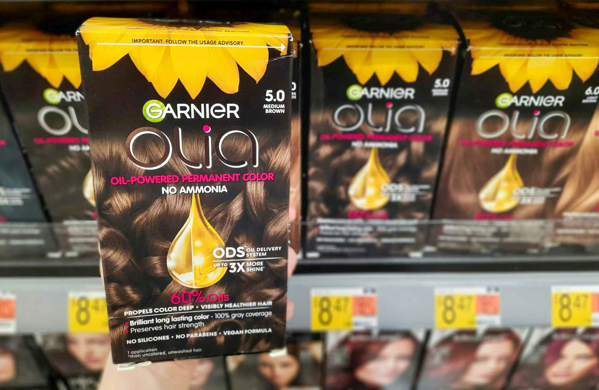 Garnier Olia Hair Color product held in front of display at Walmart