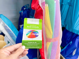 Mainstays 8-Foot Beach Umbrella tag being held at Walmart