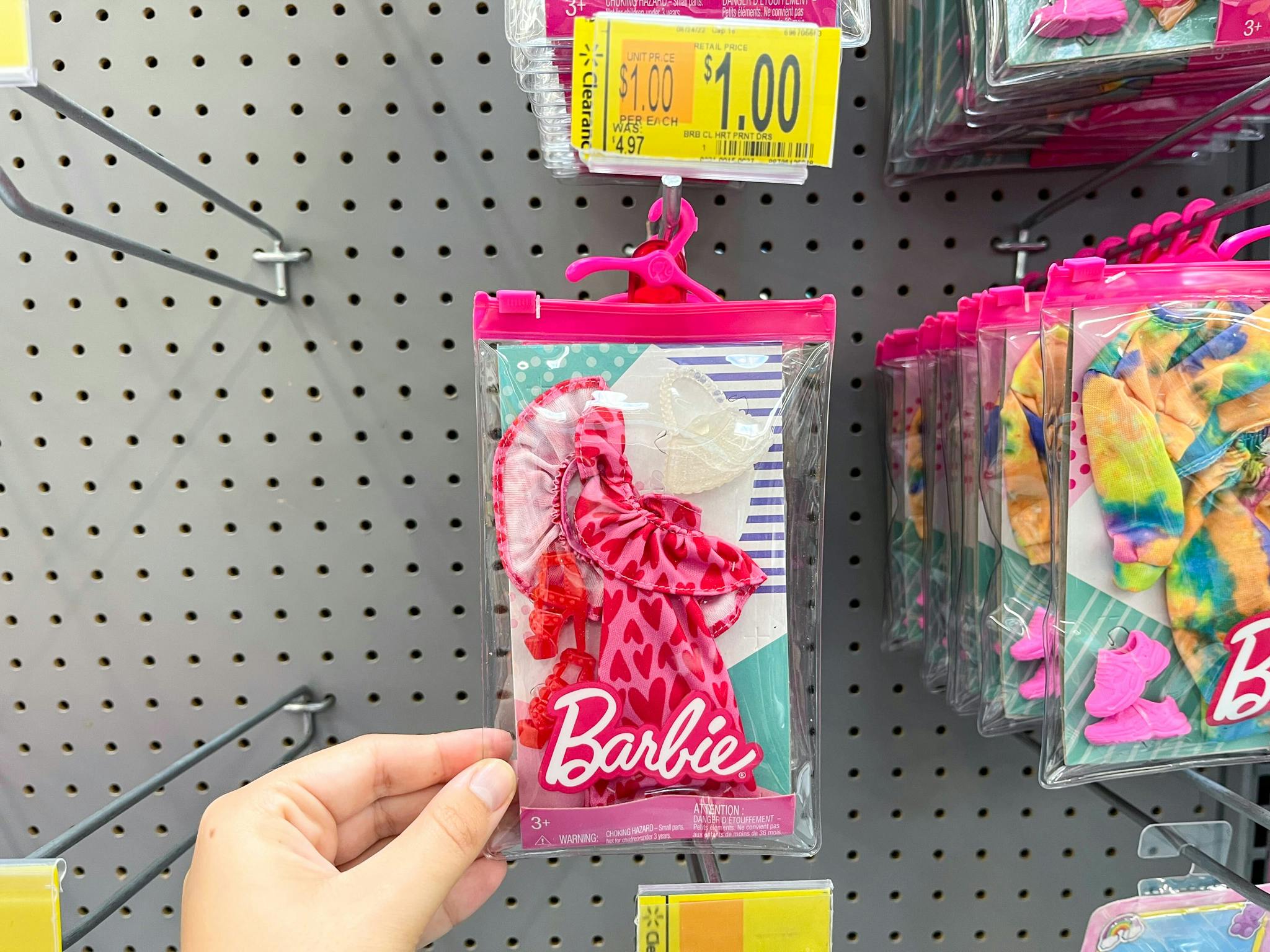 hand holding barbie doll fashion clothes on clearance at walmart