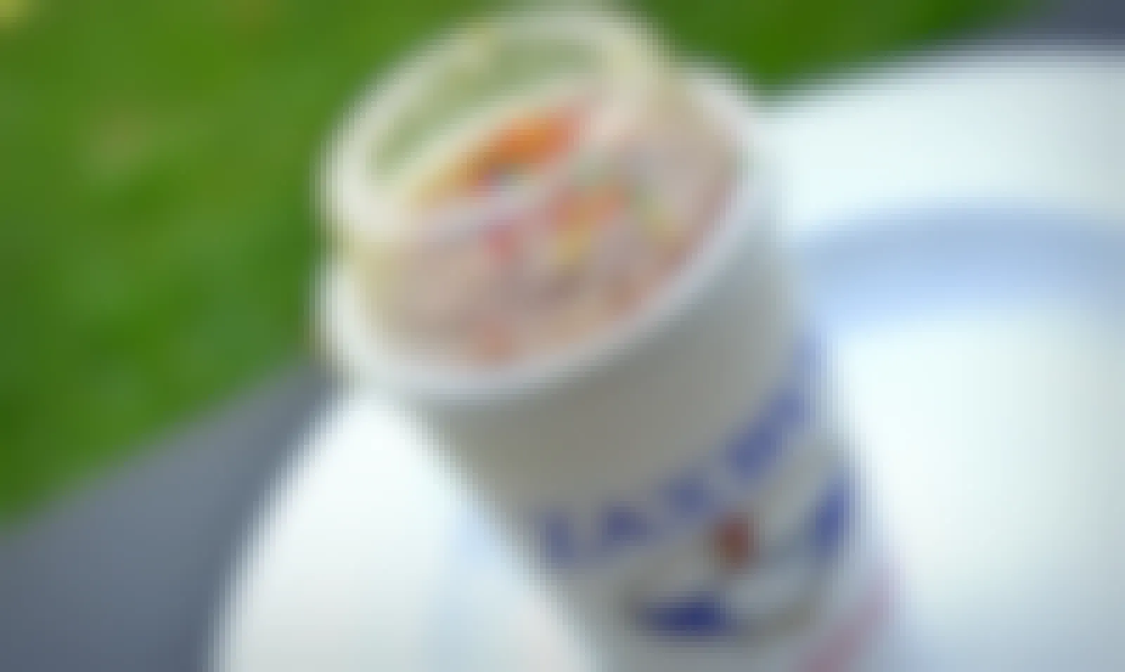 A Zaxby's milkshake with sprinkles on a table outside.