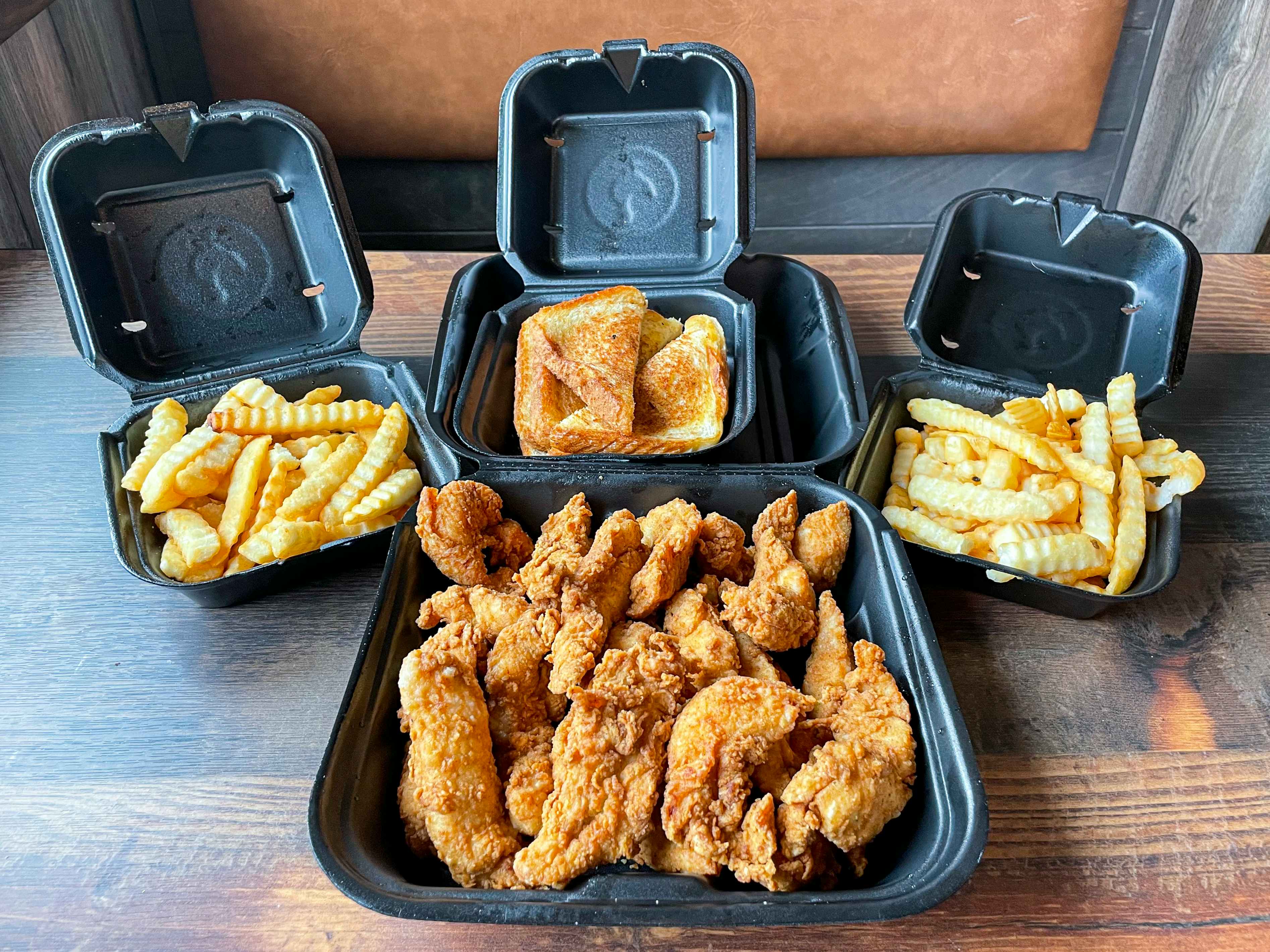 A chicken tender family meal from Zaxby's in open boxes on a table.