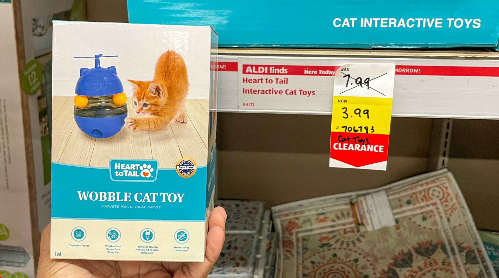 cat wobble toy held up near sales sign