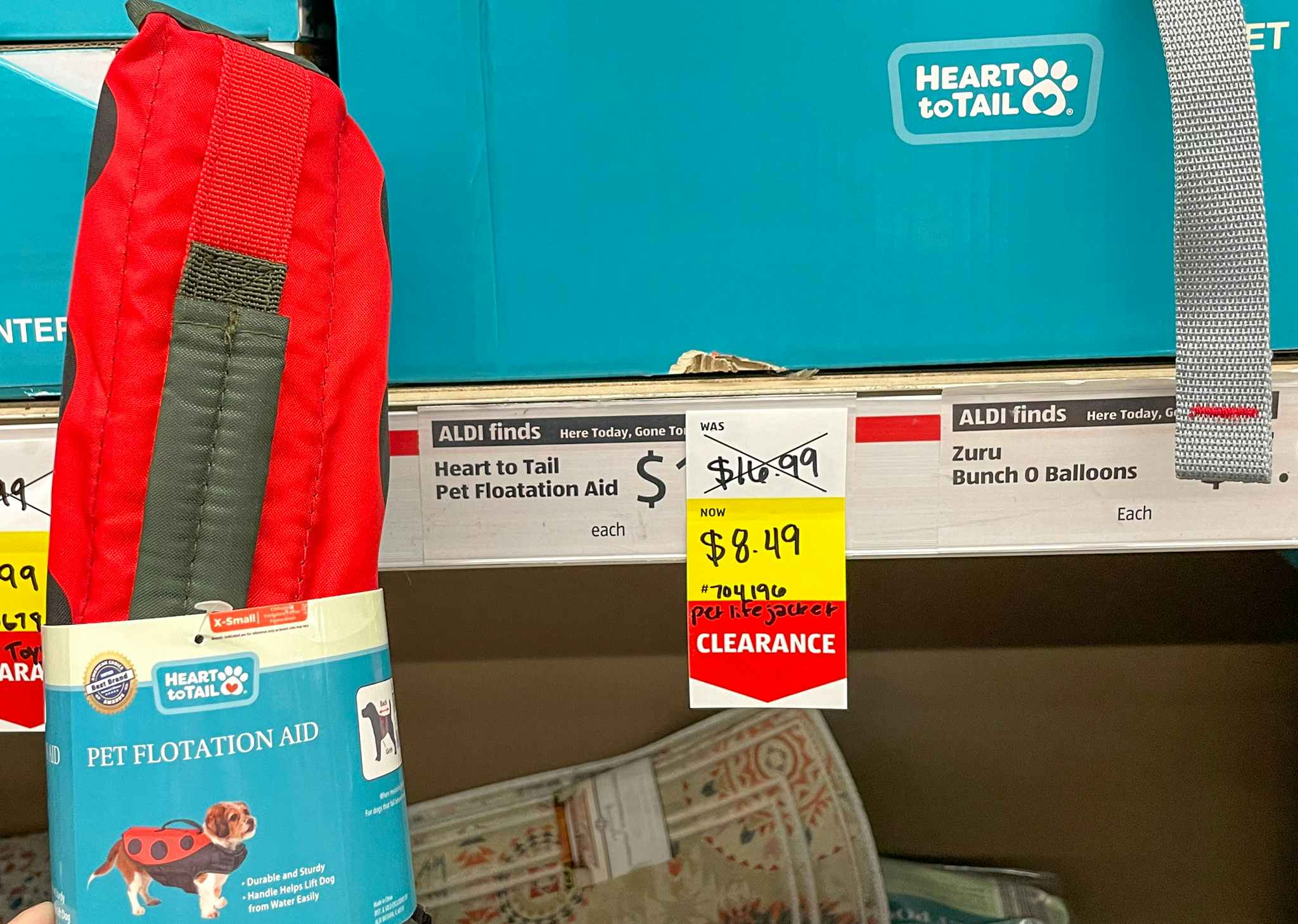 pet floatation aid held near sales sign at aldi