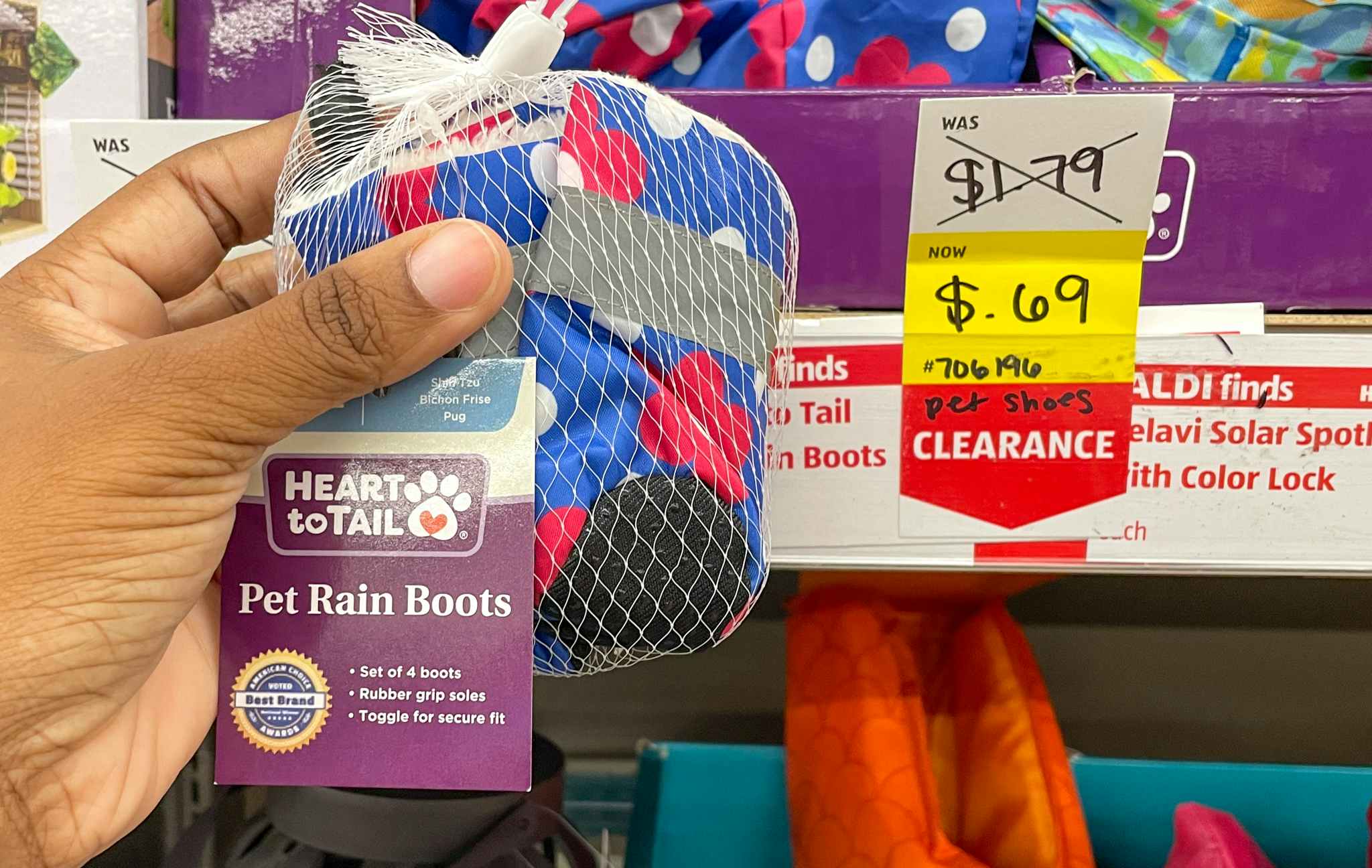 pet rain boots held up near sales sign at aldi