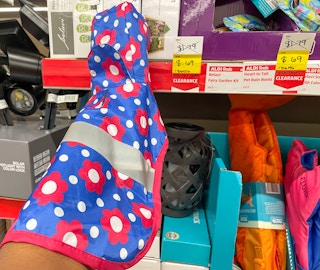 pet raincoat held up near sales sign at aldi