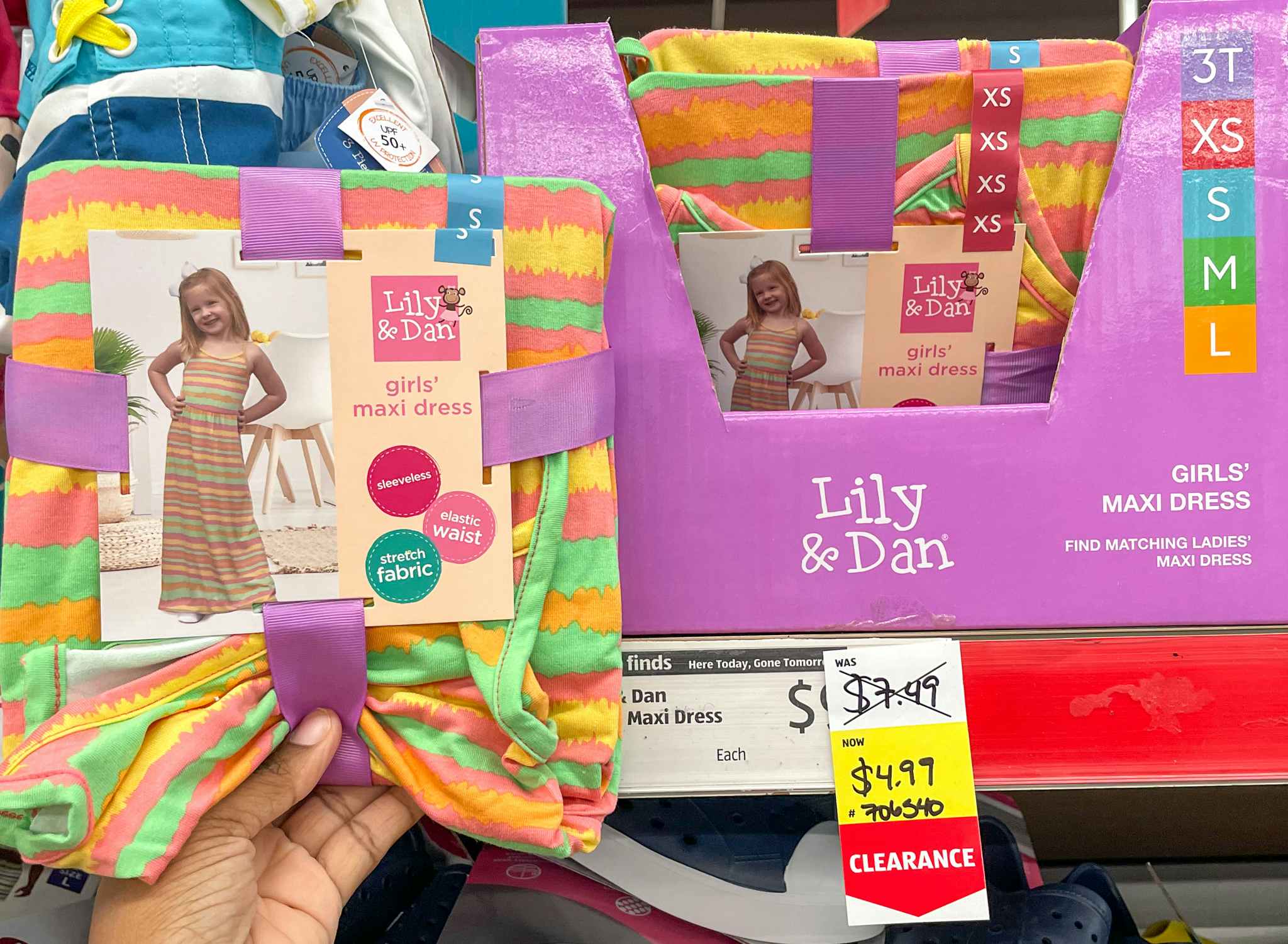 girls dress in package held up by hand near a sales tag at aldi