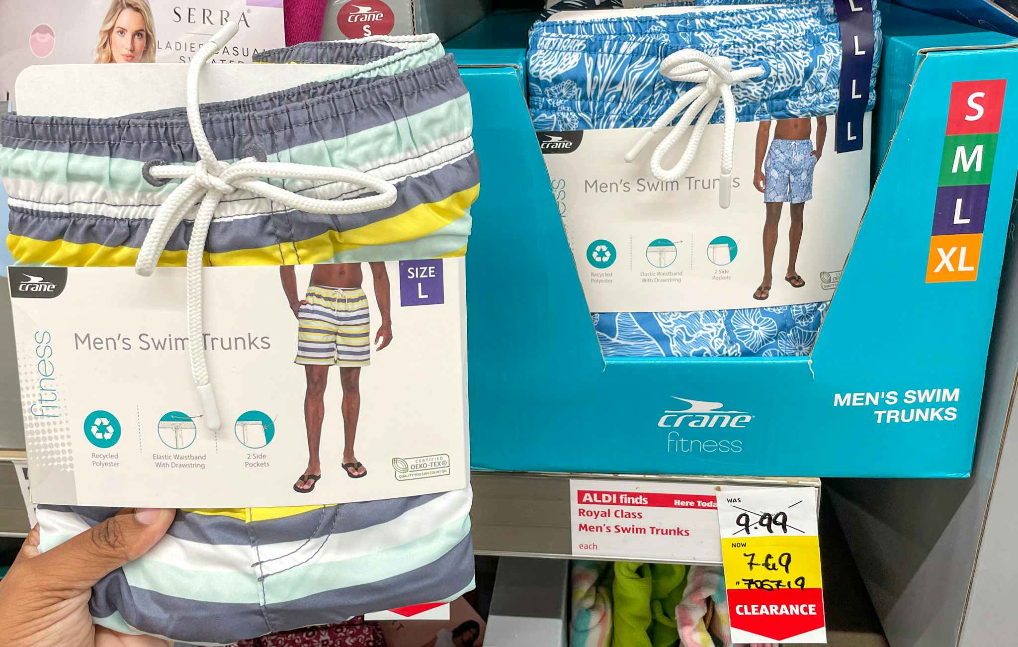 mens swim trunks held up near a sales tag at aldi