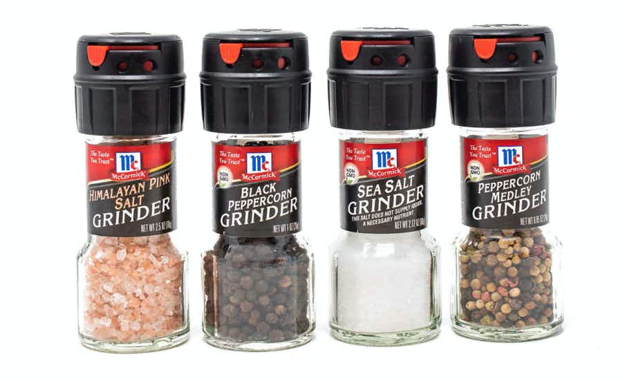 Four salt and pepper grinders on a white background
