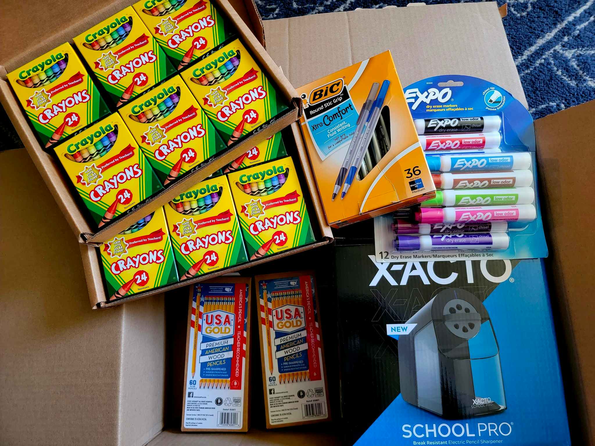 An open Amazon box filled with school supplies for a teacher.