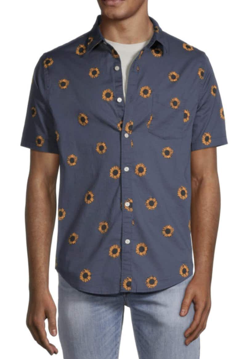 a man wearing a blue button down short sleeve shirt with orange flowers