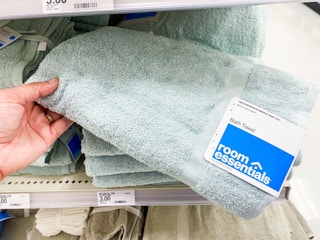 A hand holding a Room Essentials bath towel in Target