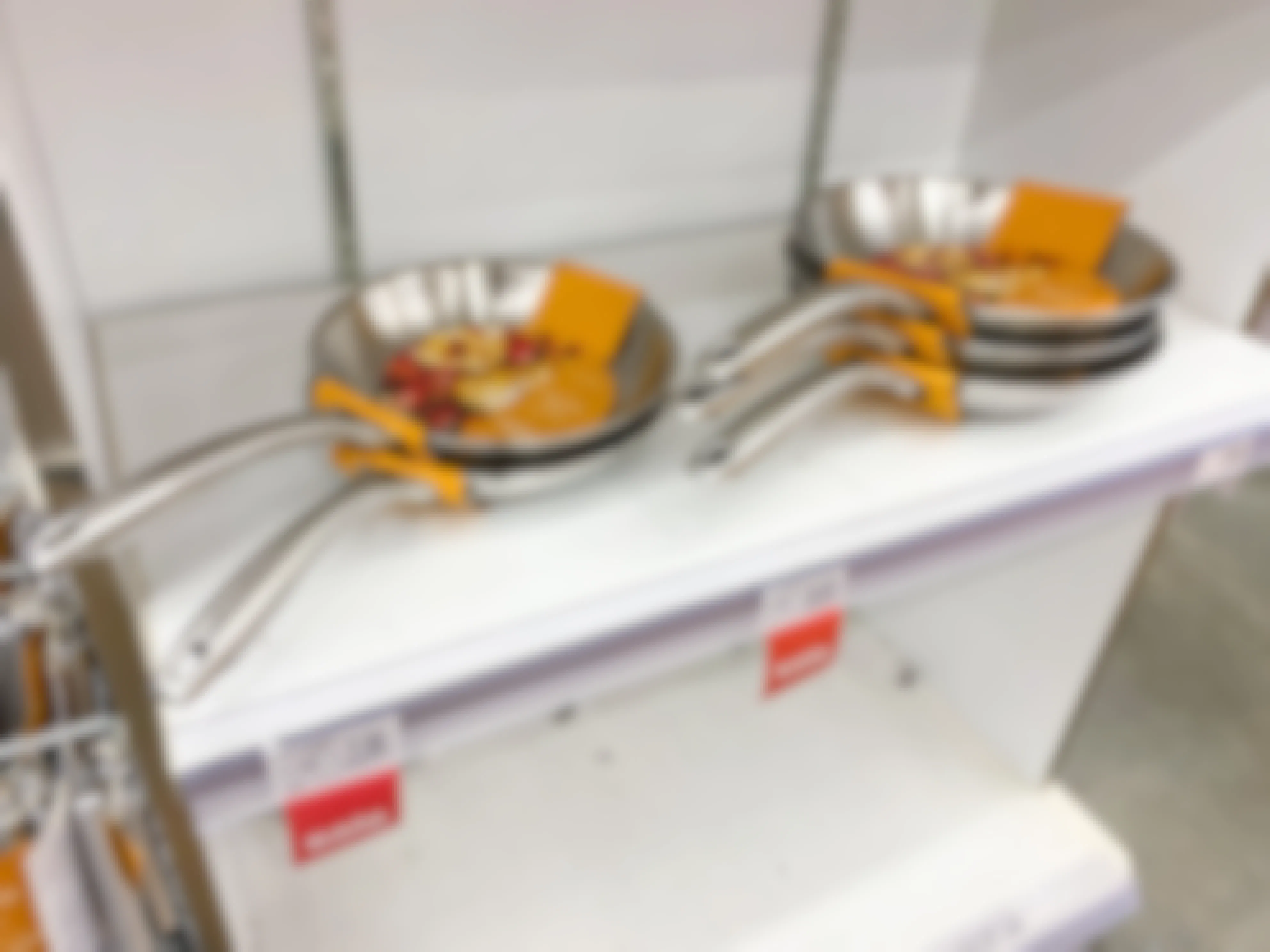 stainless steel fry pan on white shelf at angle