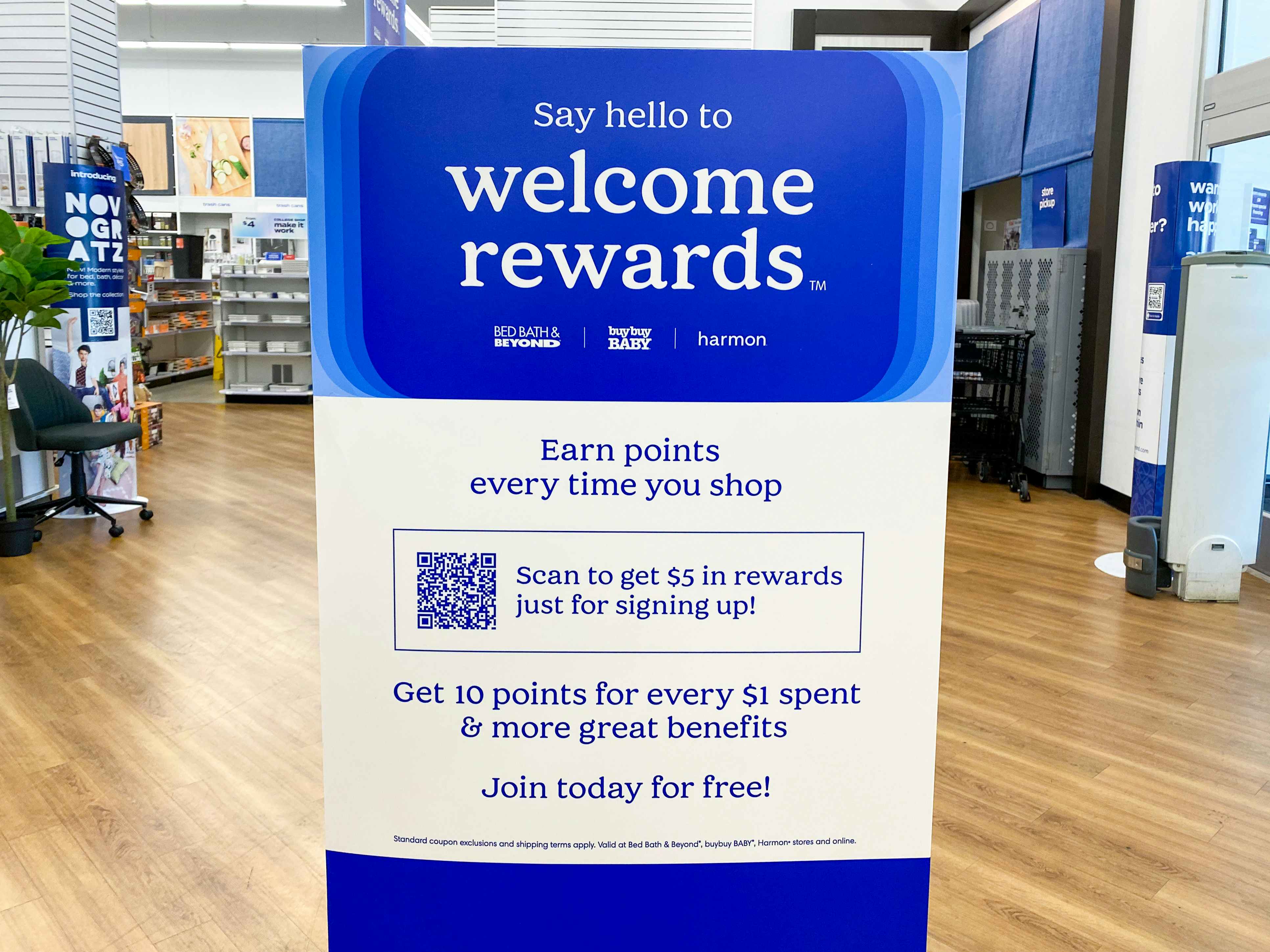 A sign for Bed Bath & Beyond's Welcome Rewards program which reads, "Earn points every time you shop. Get 10 points for every $1 spent and more great savings. Join today for free!" with a QR code to scan, offering $5 in rewards for signing up.