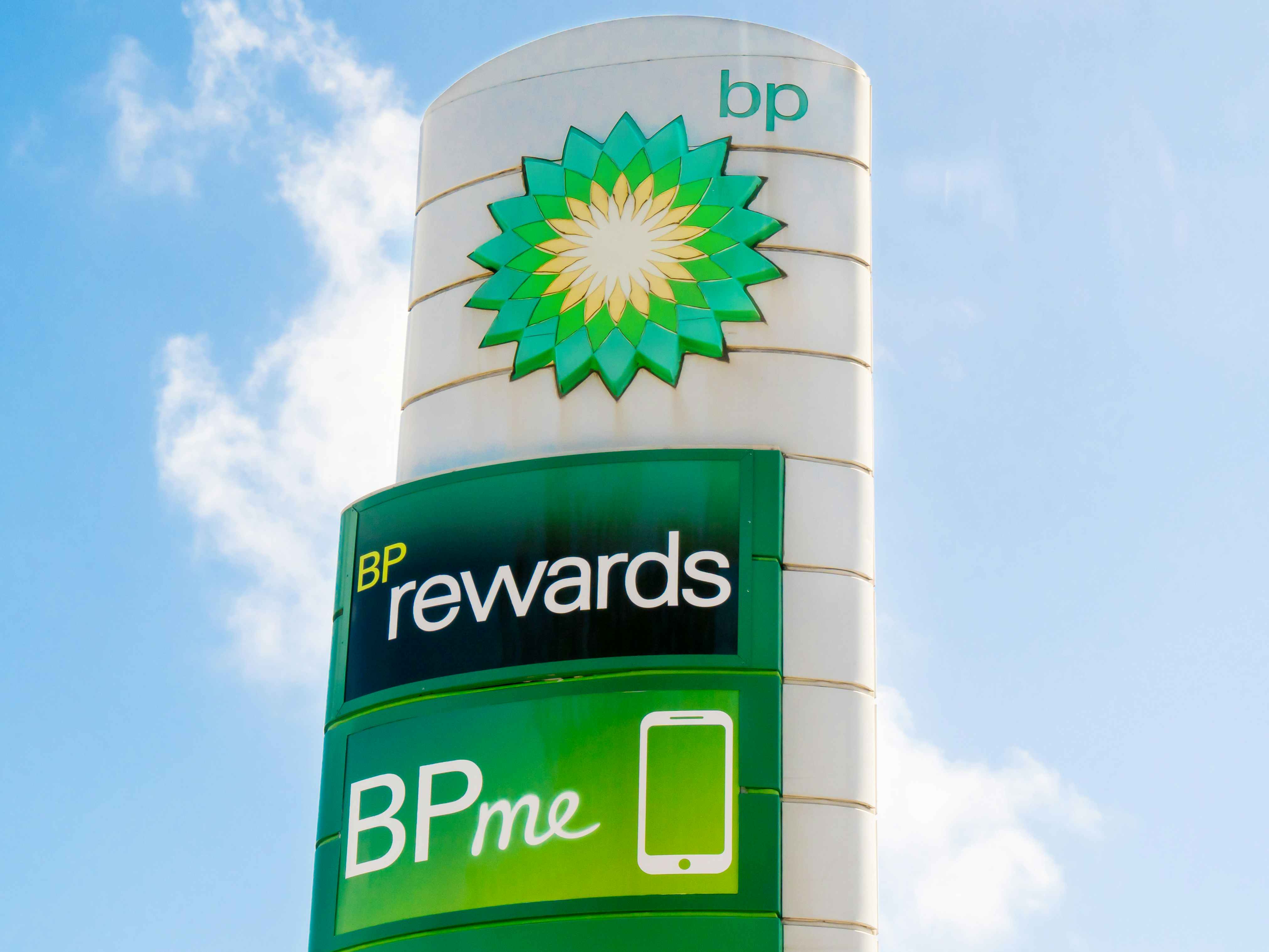 A sign next to a BP gas station advertising the BPme rewards app.