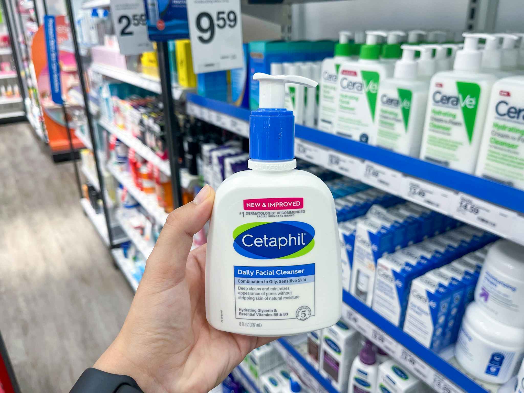 hand holding a bottle of cetaphil daily facial cleanser in front of a shelf of skin care products at target