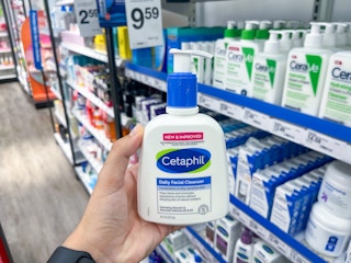 hand holding a bottle of cetaphil daily facial cleanser in front of a shelf of skin care products at target