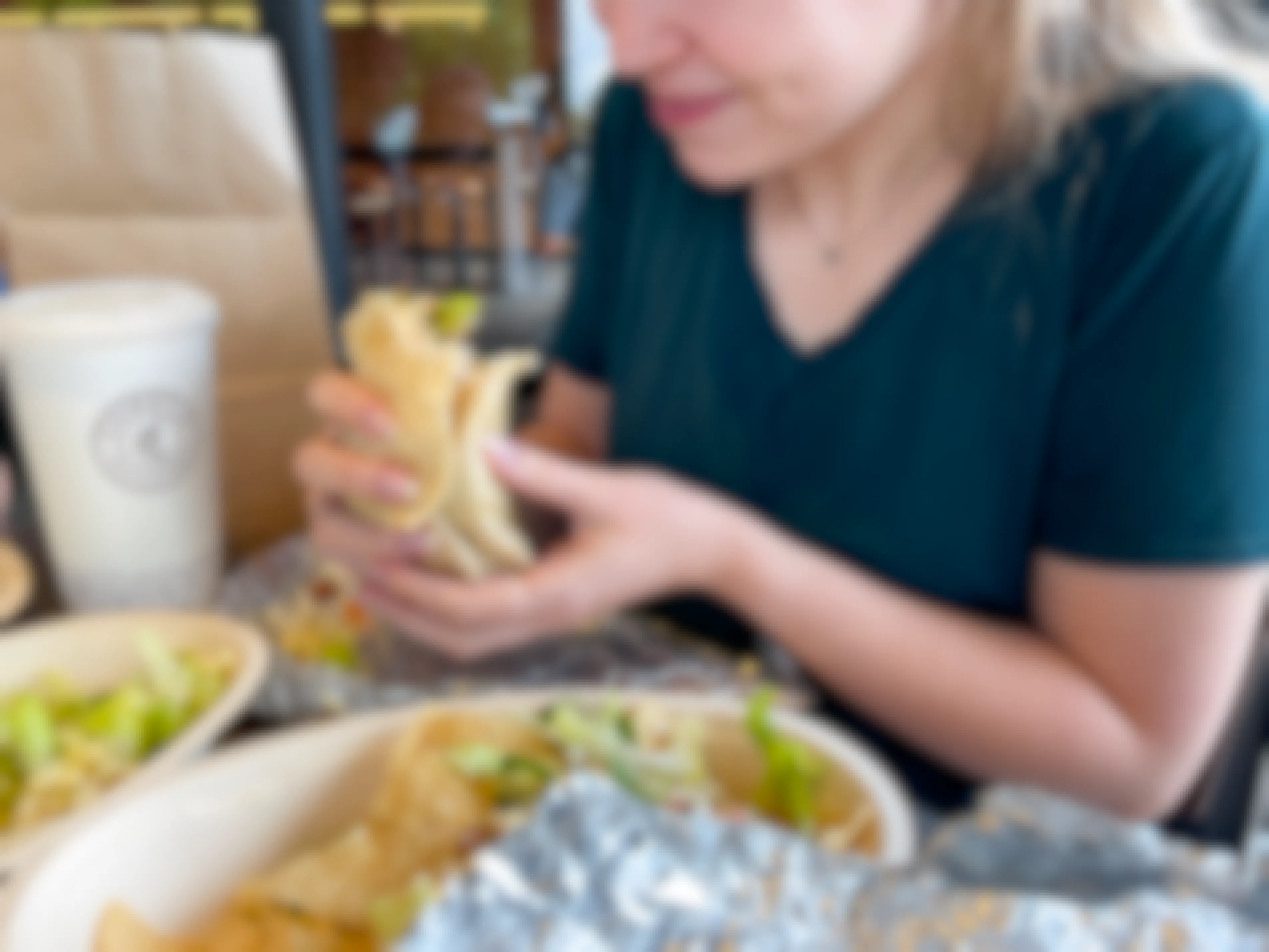 A woman eating food inside Chipotle