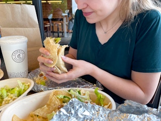 A woman eating food inside Chipotle