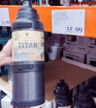 1 gallon jug hand held near sales tag at costco