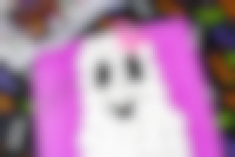 A cotton ball ghost craft on construction paper.