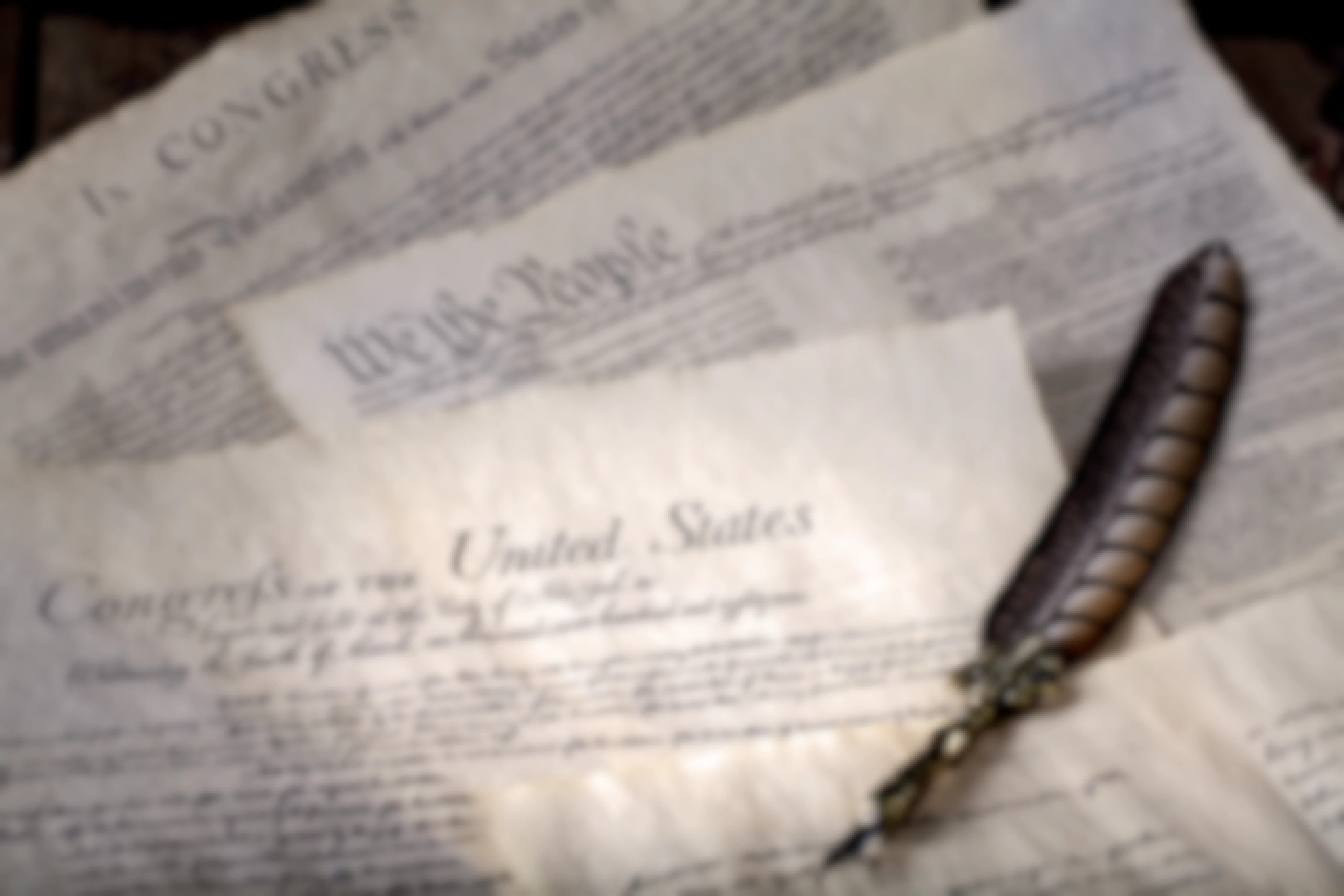 Historical documents for the United States government on a table with a quill pen.