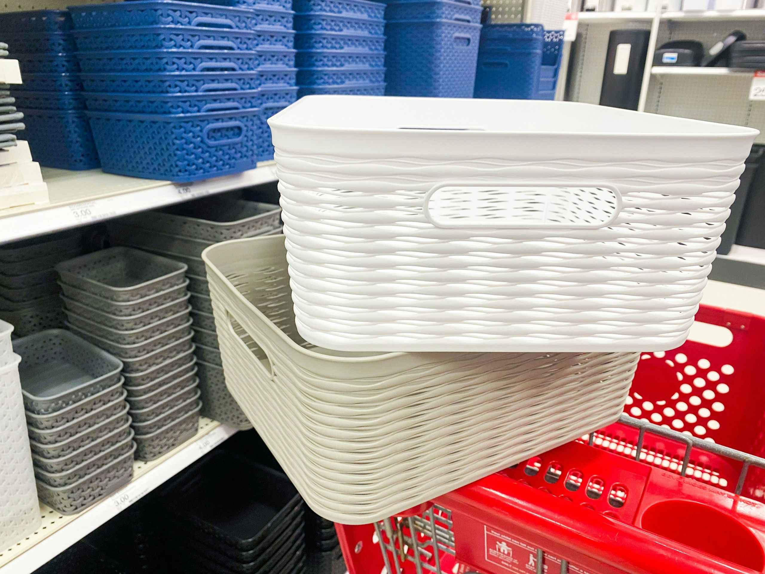 Two decorative storage baskets sitting in a Target shopping cart next to other decorative storage items