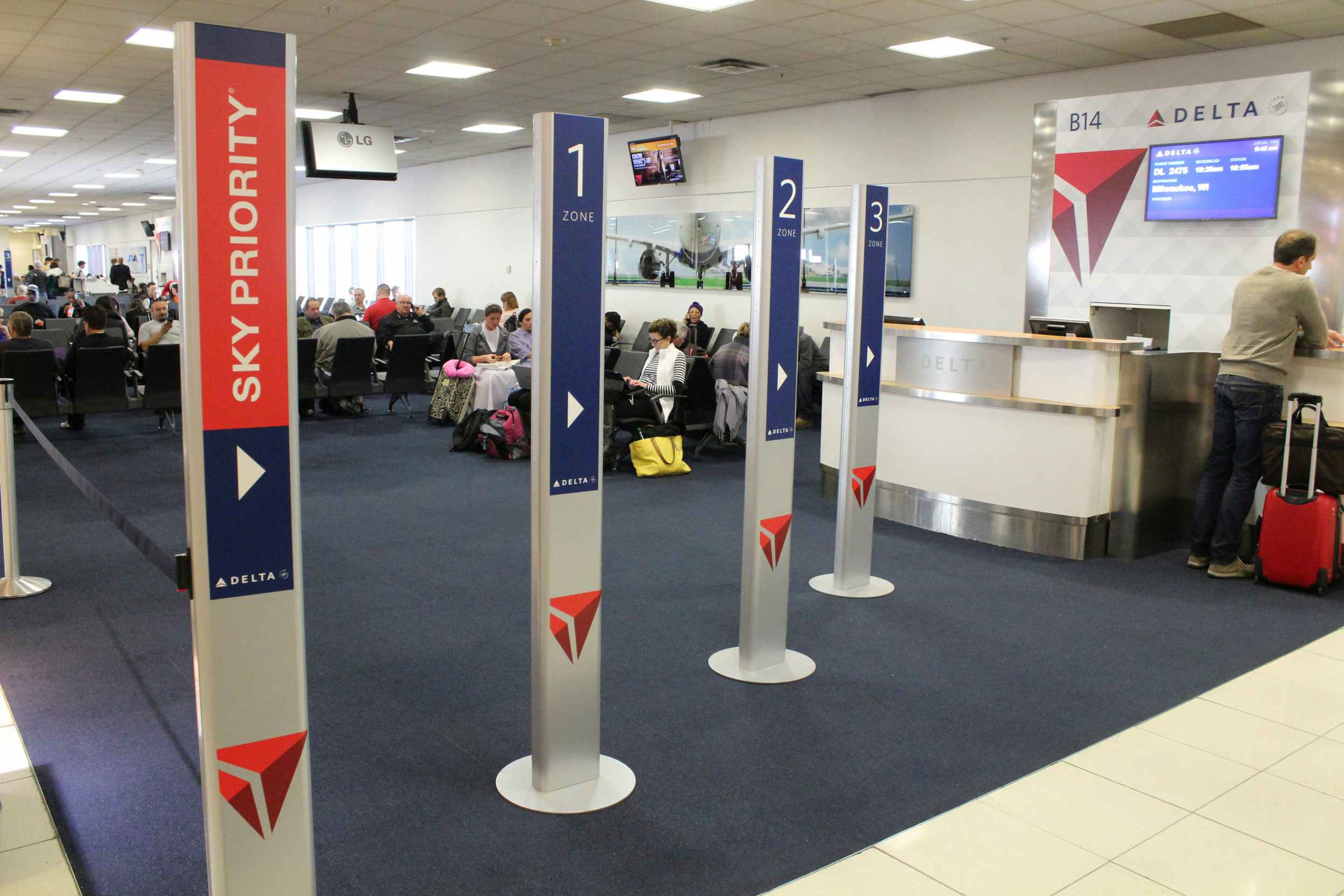 A Delta gate desk next to Sky Priority and zone signs.