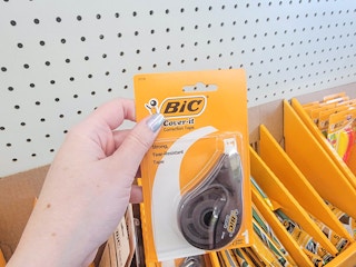 hand holding a pack of bic correction tape