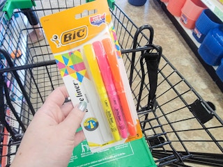 hand holding a pack of bic highlighters over a cart