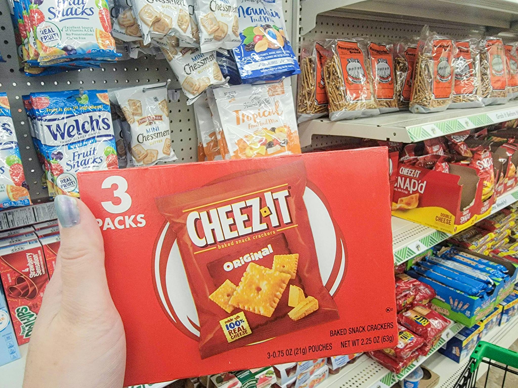 hand holding a box of 3 packs of cheez its crackers